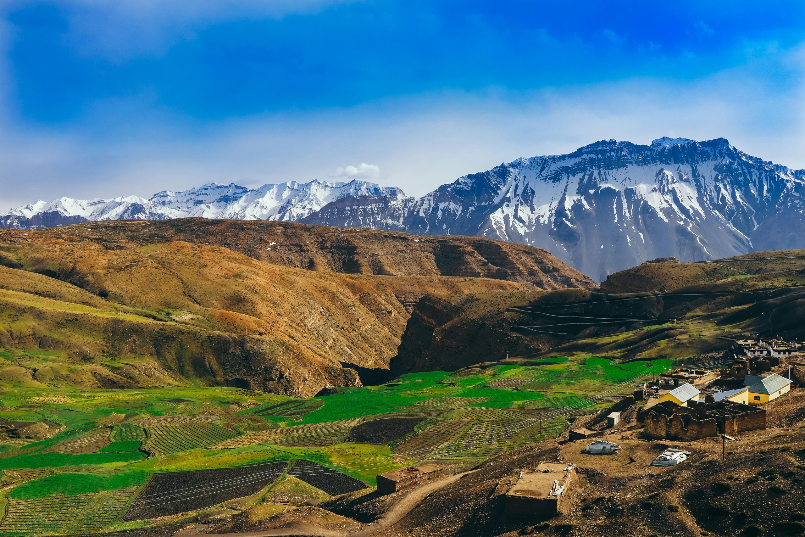 Langza Village in Spiti Valley with giant Buddha statue and snow-capped Himalayas