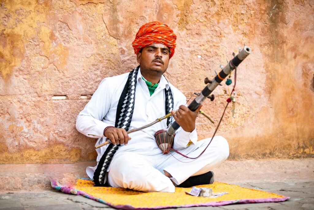 Rajasthani musician playing Ravanahatha in traditional attire, Rajasthan, India