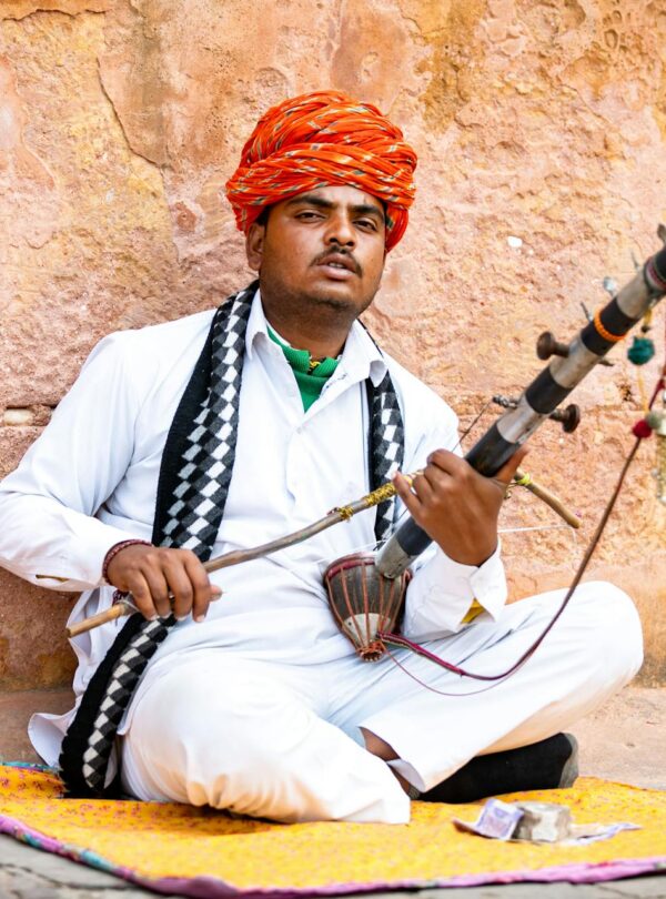 Rajasthani musician playing Ravanahatha in traditional attire, Rajasthan, India