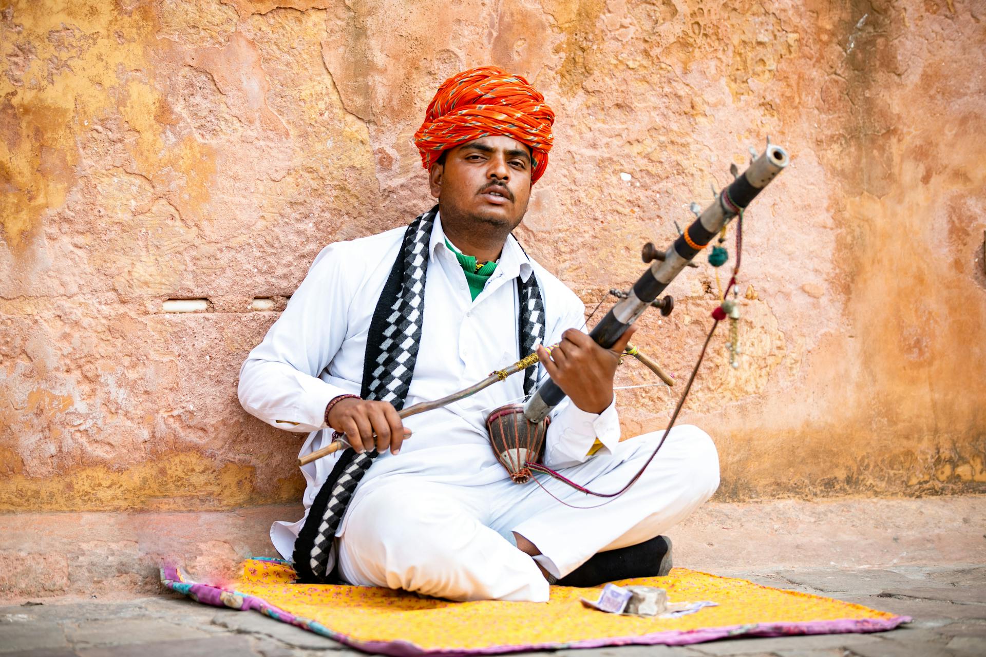 Rajasthani musician playing Ravanahatha in traditional attire, Rajasthan, India