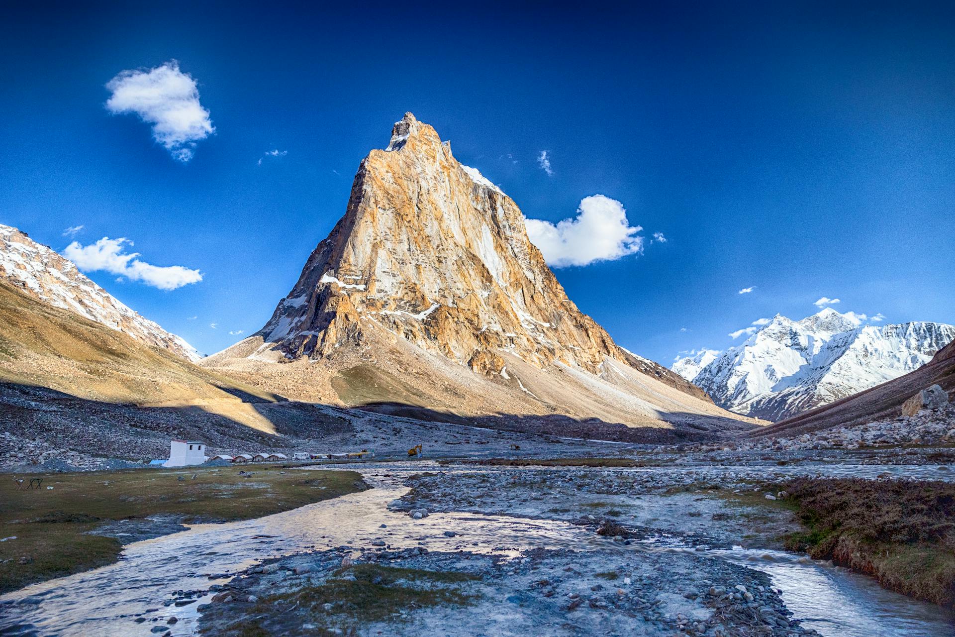 Snow-capped Gonbo Rangjon Peak towering over Zanskar Valley with rugged Himalayan terrain and clear skies.