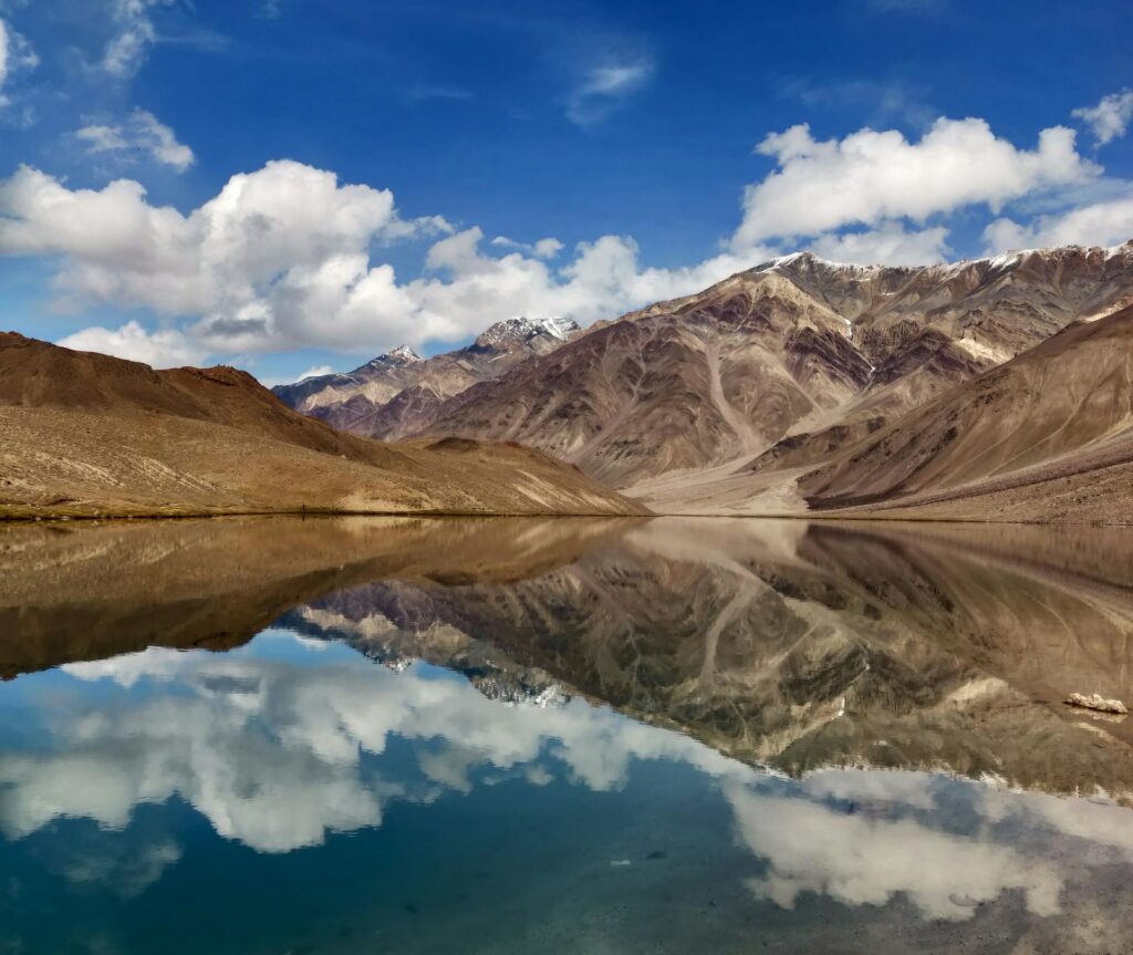 Chandratal Lake in Spiti Valley with crescent-shaped turquoise waters surrounded by snow-capped Himalayan mountains