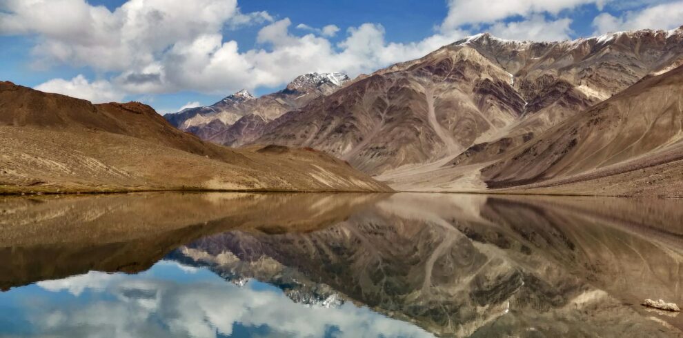 Chandratal Lake in Spiti Valley with crescent-shaped turquoise waters surrounded by snow-capped Himalayan mountains